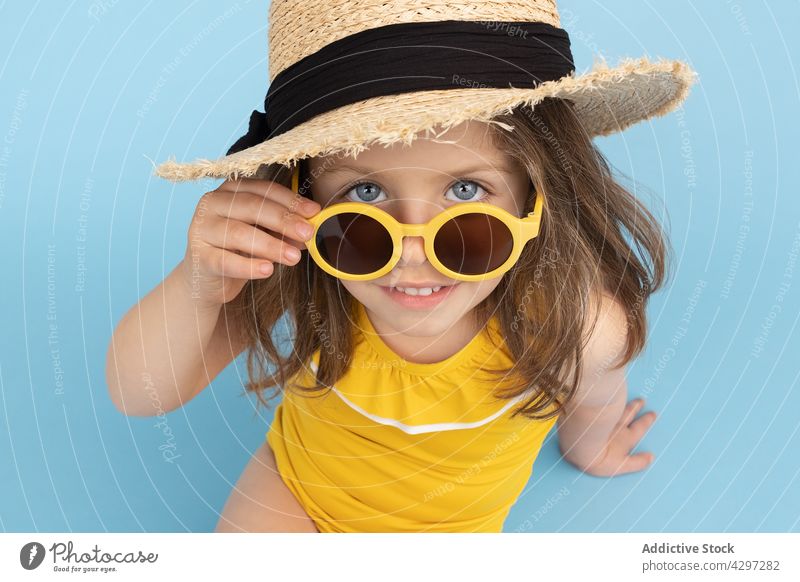 Stylish little girl in summer outfit style yellow fashion happy smile kid sunglasses beach child cute bright cheerful trendy carefree straw hat color cool