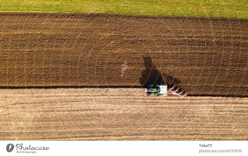 a tractor plows a field from above farming farming with a tractor crops plowing a field sun modern farming modern tractor earth green food farming