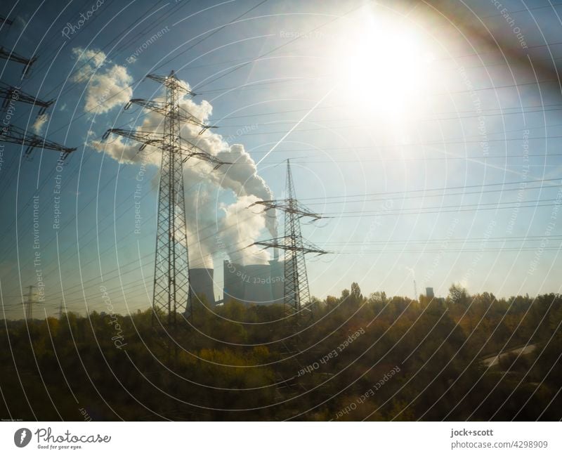 Power plant passes the moving train power station Energy industry Industry Sun Clouds Chimney Environmental pollution Air pollution motion blur