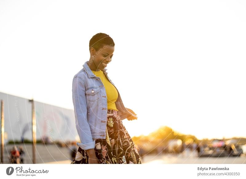 Smiling young woman enjoying the outdoors at sunset afro proud real people city life African american afro american student Black ethnicity sunny outside pretty