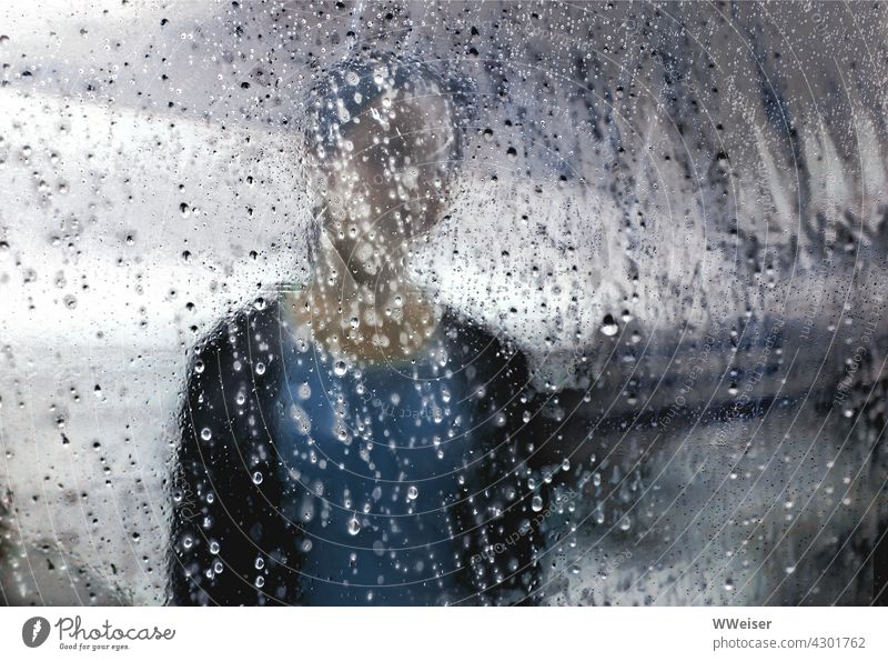 A sad girl, blurred against a dramatic sky, behind a transparent tarp full of raindrops Girl melancholy Meditative Lonely Rain Drop tarpaulin Sheath plastic