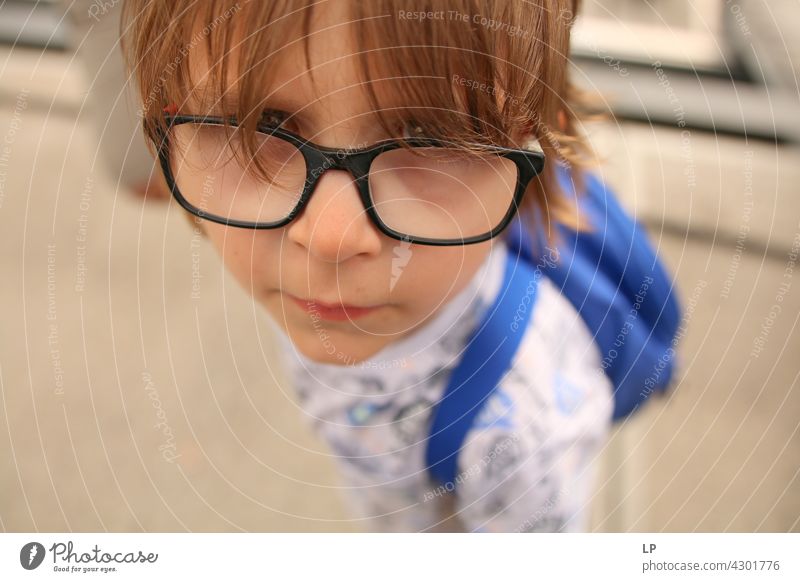 child wearing glasses looking curious at the camera Style Design Human being Emotions Colour photo Child Parents Contrast Neutral Background