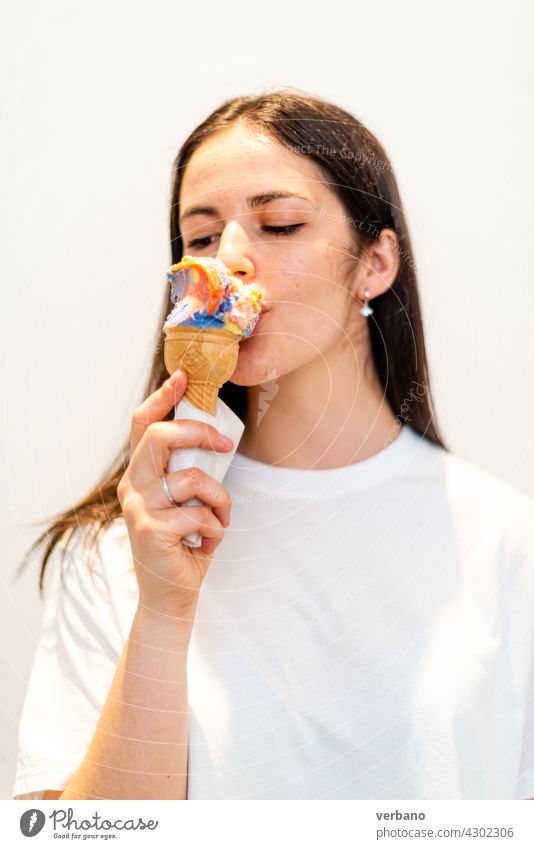 Young girl eating a colorful gelato icecream white woman young beautiful beauty happy face people food smile smiling portrait isolated person brunette lollipop