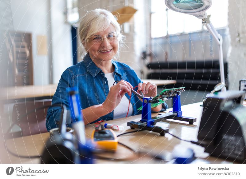 Senior woman in electronics workshop measurement current electricity Electrician Engineer Equipment Expertise Industry Job Repair soldering iron indoors female