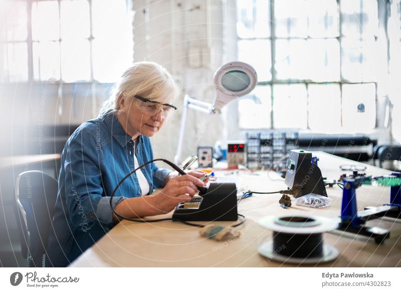 Senior woman in electronics workshop measurement current electricity Electrician Engineer Equipment Expertise Industry Job Repair soldering iron indoors female