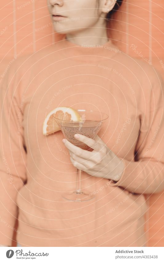 Crop woman with cocktail in studio martini minimal refreshment drink pink color pastel female beverage glass slice alcohol fruit grapefruit garnish delicious