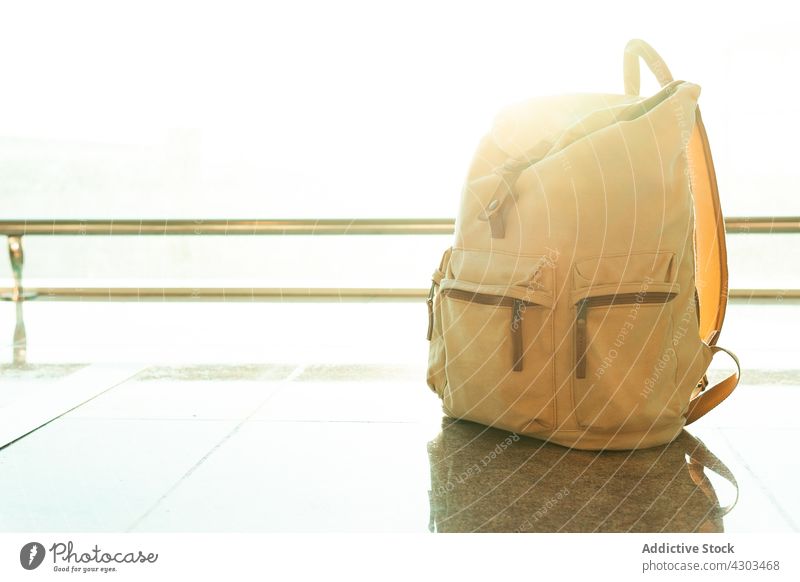 Backpack near window in airport backpack travel rucksack departure lounge baggage luggage vacation concept destination terminal sunlight material textile fabric