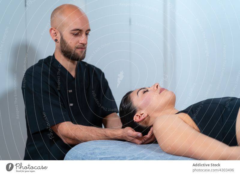 Physical therapist examining neck of patient in clinic doctor examine eyes closed massage rehabilitation work man woman mindfulness relax physiotherapy