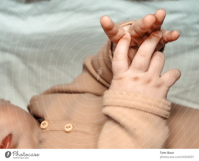 playing baby hands of an infant lying on the bed closeup Playing Baby Infancy Child Cute pretty Innocent Touch Horizontal cute Small Delightful Newborn