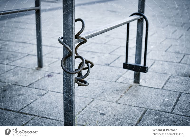 two bicycle locks on a bicycle stand stolen Bicycle complete secure sb./sth. stealing bicycle thief Thief Spiral lock U-lock Metal urban Town City life