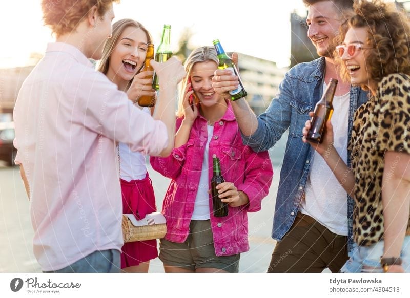 Group of friends drinking beer together Group of people woman women young casual beautiful attractive girls male female friendship smiling happiness happy