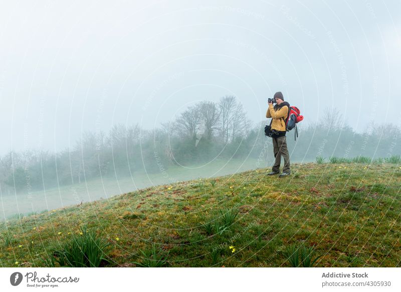 Unrecognizable traveling woman taking photo of highlands traveler take photo mountain adventure photographer fog photo camera photography field female meadow