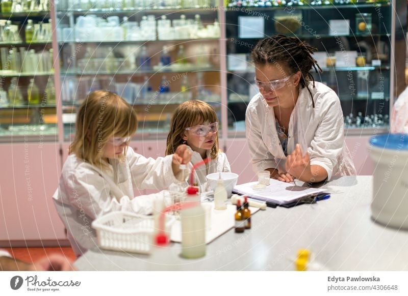 Children and their teacher in a science class experiment expert learning kids children education young people female adult happy woman sitting caucasian person