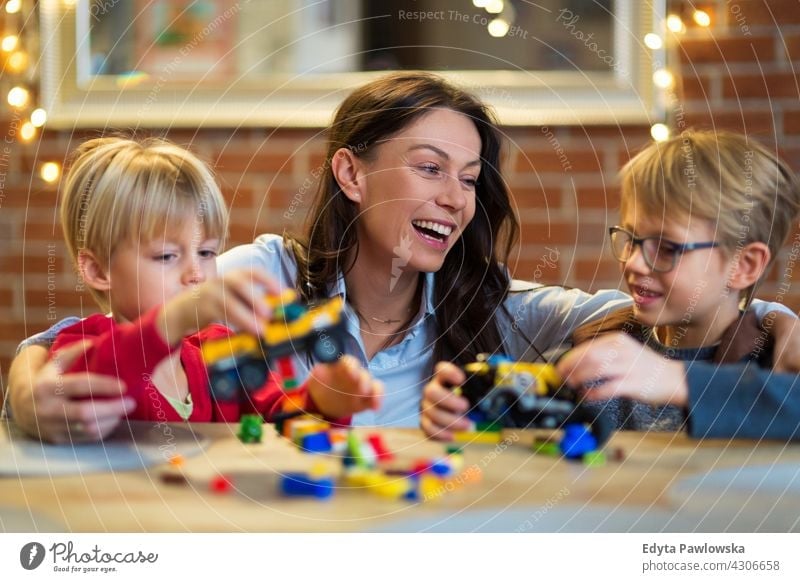 Mother and Children Playing with Blocks At Home education learning playing toy preschool building blocks family parent parents relatives relationship woman