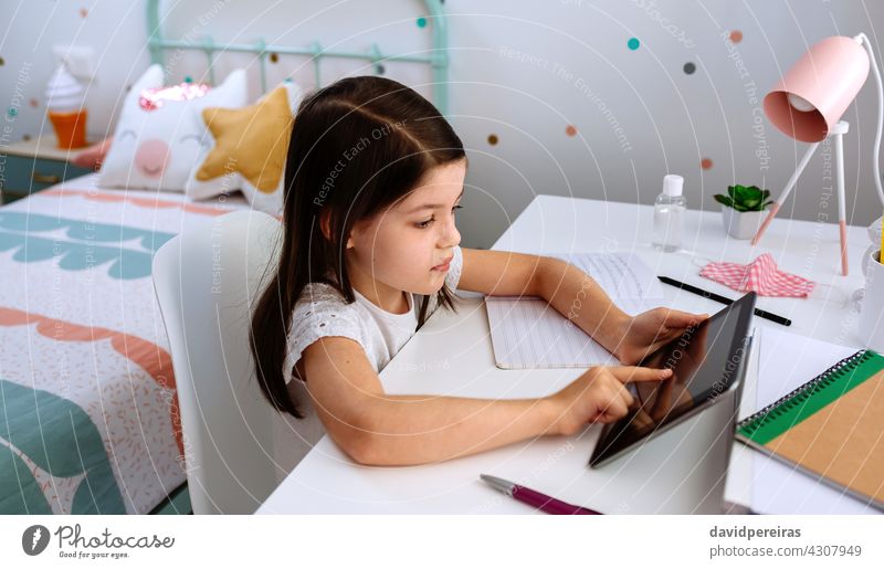 Girl studying at home with tablet and mask on table girl school at home home schooling coronavirus covid-19 digital wisdom social distancing homework watching