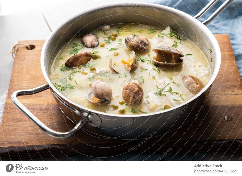 Saucepan of seafood soup in kitchen saucepan board meal delicious lunch cuisine tasty dish hake fish clam herb pea ingredient recipe yummy prepare appetizing