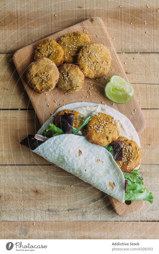 Tortilla with falafel and lettuce on cutting board tortilla wrap lime table kitchen sweet potato tradition food meal delicious tasty yummy dish fresh cuisine