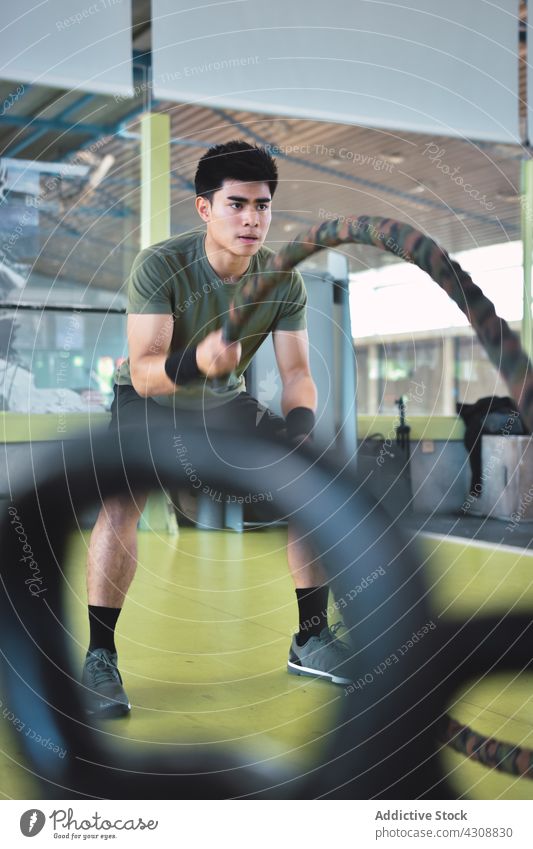 Asian male training with battle rope man asian athlete athletic ropes body crossfit exercise fitness functional gym health lifestyle muscular sport strength