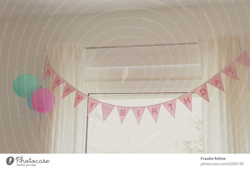 Happy Birthday pennant chain and three balloons on a curtain rod celebrate a birthday Feasts & Celebrations Interior shot Party Pink Decoration