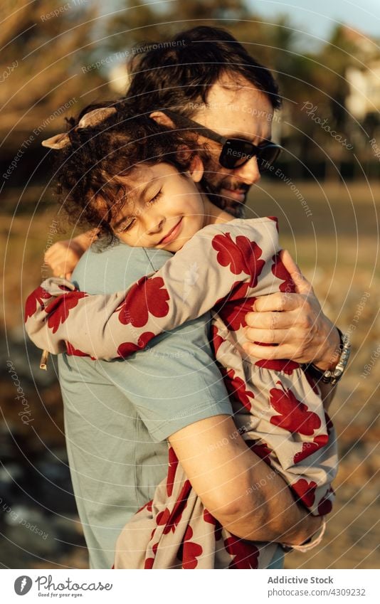 Father hugging daughter in nature father countryside rest weekend carry together love summer man girl happy embrace relationship eyes closed child kid relax