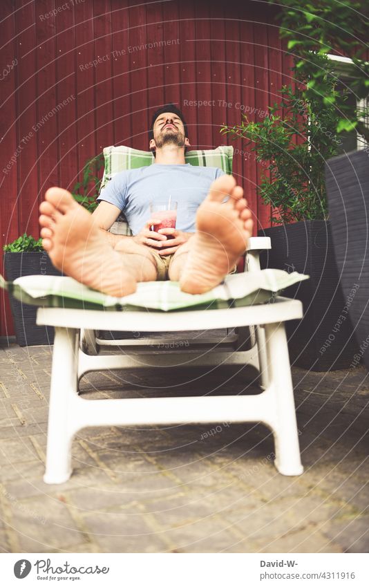 Man enjoying a cocktail on the lounger in summer Break Couch To enjoy Cocktail Garden rest Summer Lie Relaxation Cozy vacation at home chill