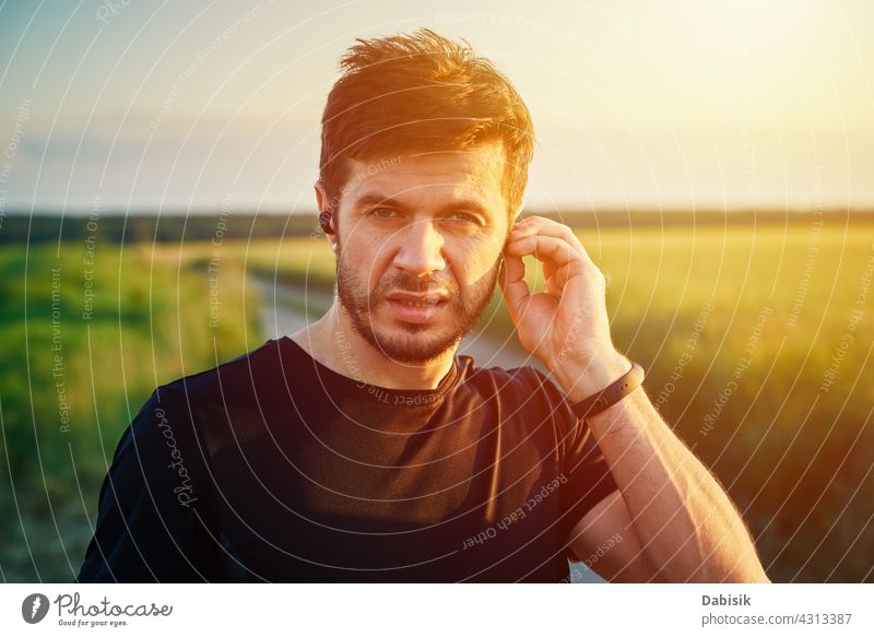 Active millenial man portrait outdoors at sunset sport caucasian lifestyle athlete fitness generation headphones beard casual exercise outside sporty young