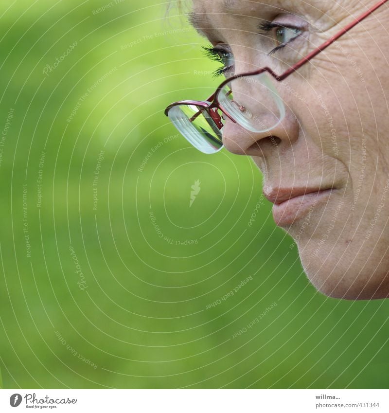 Mature woman looks sceptically over her glasses Woman Adults Face Eyeglasses Observe Think Looking Friendliness Curiosity Green Compassion Attentive