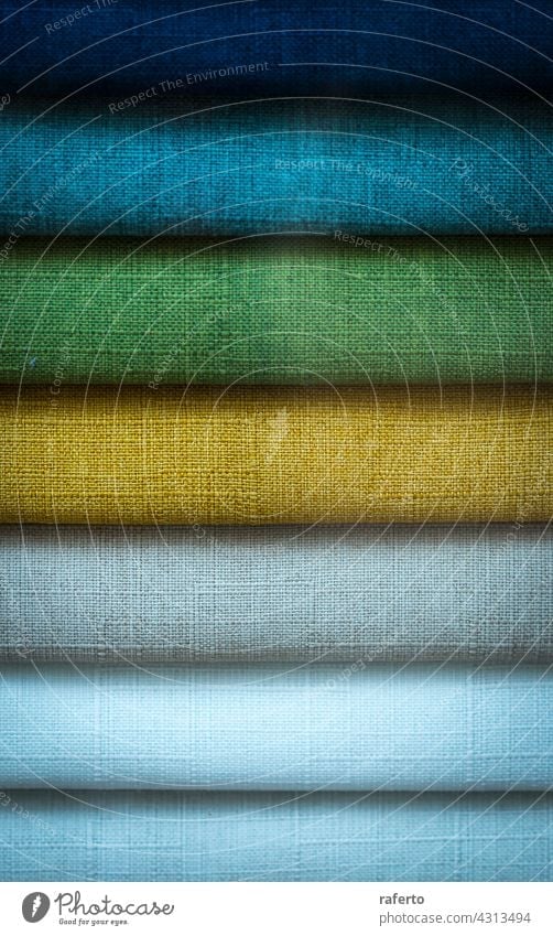 A Stack of some colored fabrics textile stack clothes cotton background fashion material pattern clothing texture blue green yellow folded rainbow pile bright