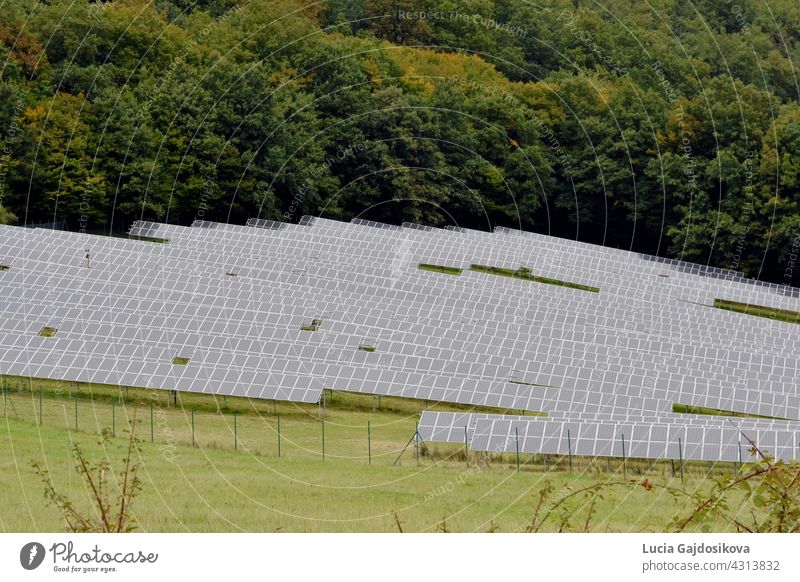 Solar panels placed on a meadow in dense rows, in Zarnovica, district town in Slovakia, Europe. An example of use of renewable resources for production or generation of electricity.
