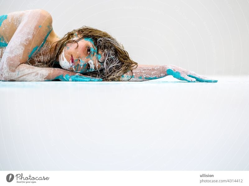 Portrait and arm of a sexy young woman in white and turquoise color painted decorative. Creative expressive abstract body painting art, copy space. bodypainting