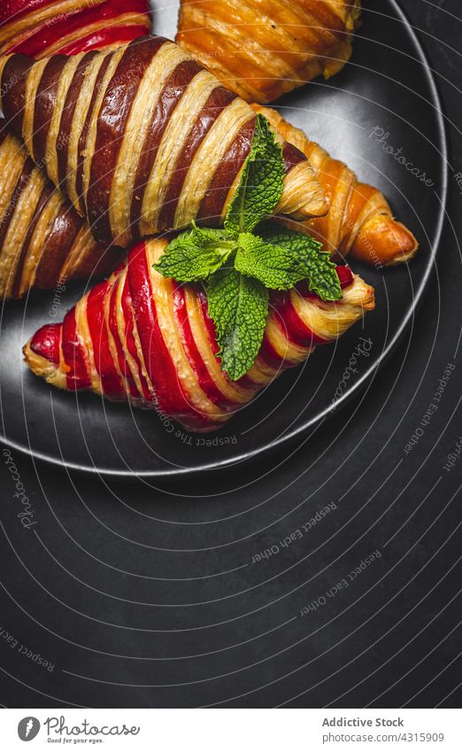 Appetizing croissants in basket on table breakfast dessert serve sweet treat baked pastry delicious tasty fresh appetizing food gourmet yummy meal sprig mint
