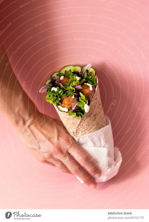 Anonymous person hands holding vegan falafel wrap durum isolated ingredient fast food fajitas shawarma halal chickpeas restaurant balls arabian tasty turkish