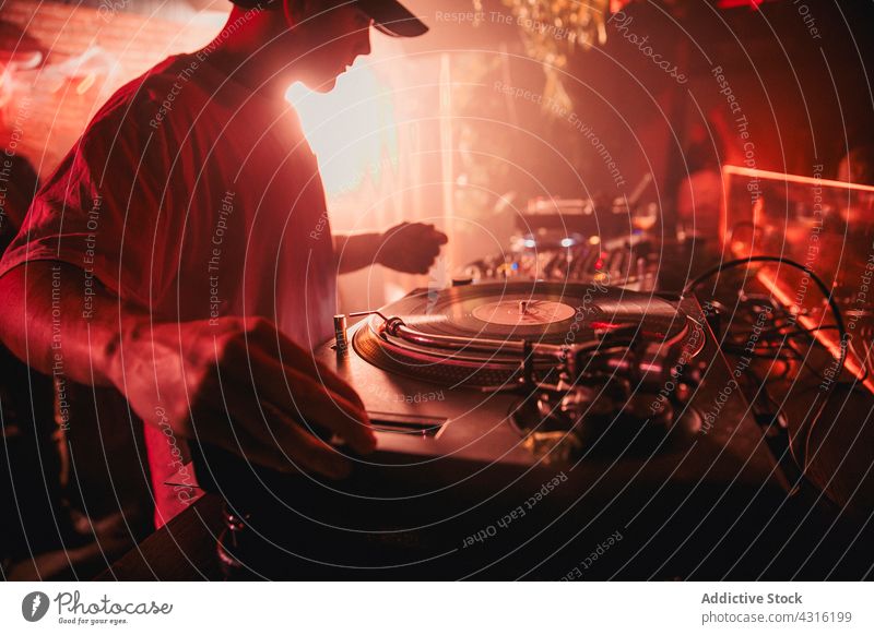 DJ mixing music during party in club dj nightclub controller concert man neon male sound entertain audio perform equipment mixer song play nightlife melody