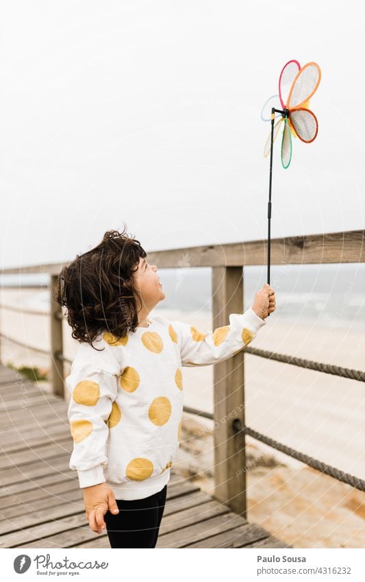 Child holding windmill toy on the beach Caucasian Girl 1 - 3 years Wind Windmill Playing Leisure and hobbies Joy Lifestyle Infancy Toddler Colour photo
