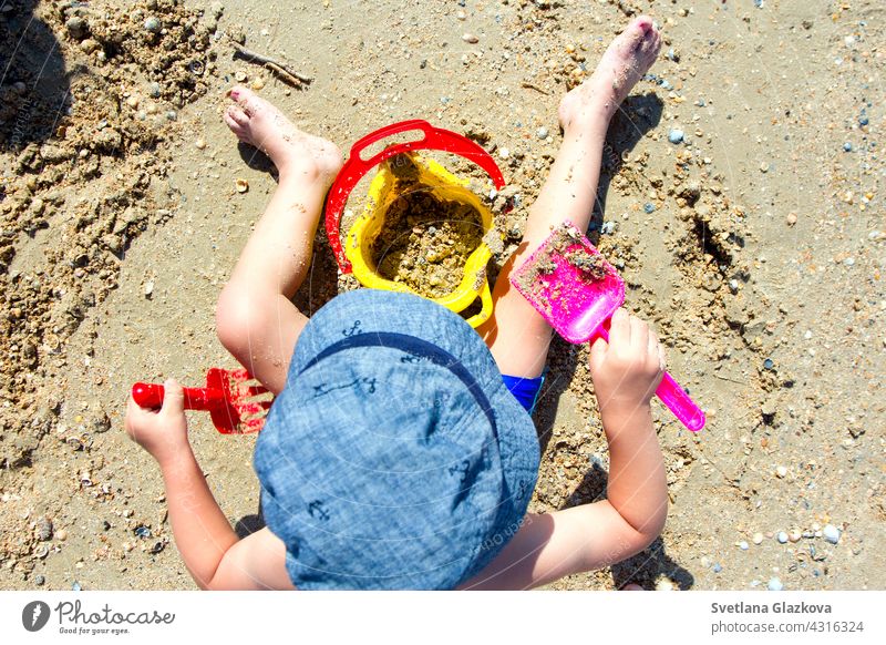 child playing with sand, shovel, bucket beach baby castle summer little building toddler kid vacation joy leisure toys childhood sandcastle cute fun nature boy