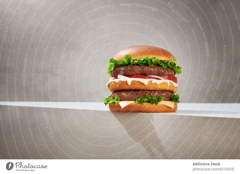 Appetizing double burger on gray background fast food tasty cutlet junk food delicious cheese meal bun lettuce fresh gourmet appetizing yummy unhealthy