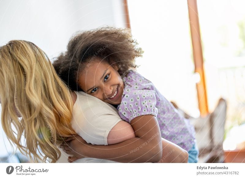 Mother and daughter having fun together at home mother child family multi-ethnic mixed race family diverse family diversity afro real people millennial hair