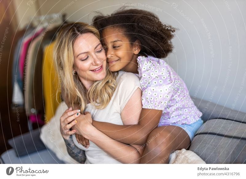 Mother and daughter hugging at home mother child family multi-ethnic mixed race family diverse family diversity afro real people millennial hair girl children