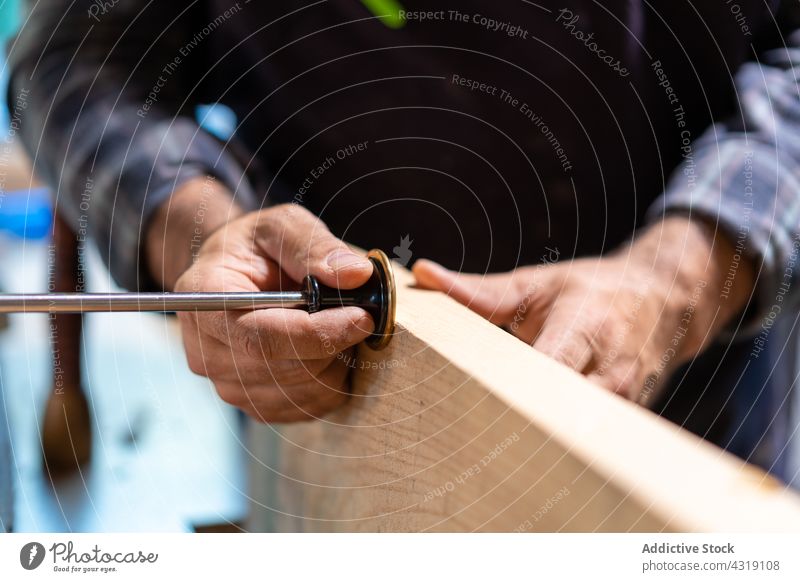 Carpenter using marking gauge for woodwork carpenter woodworker man joiner tool measure workshop carpentry craftsman male artisan plank skill joinery master