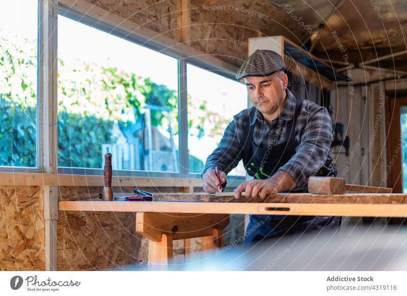 Joiner measuring wooden plank in workshop carpenter woodworker measure man joiner mark pencil ruler carpentry craftsman male artisan skill joinery tool master