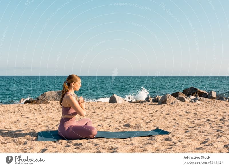 Woman meditating in Lotus pose on beach woman yoga meditate lotus pose asana zen relax padmasana harmony female mindfulness tranquil wellness healthy