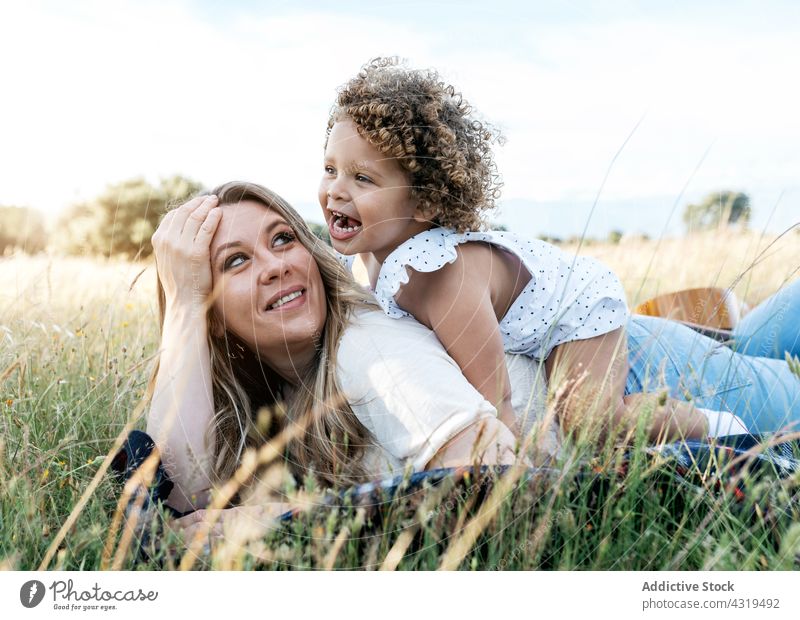 Happy mother and daughter in field together summer enjoy spend time love little child kid happy meadow girl bonding lying parent nature blanket childhood