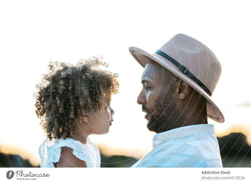 Black father holding cute daughter at sunset child together parent love black african american ethnic relationship dad little affection curly hair afro