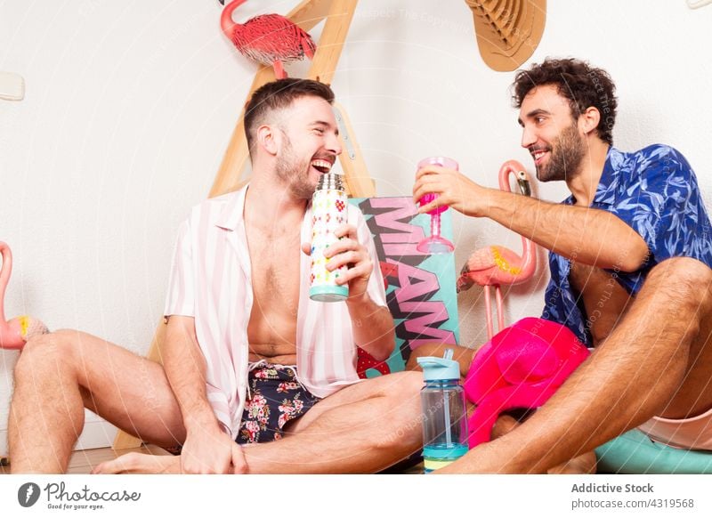 Cheerful gay couple enjoying beach party homosexual lgbt summer drink men together funny having fun chill pretend multiracial multiethnic diverse rest leisure