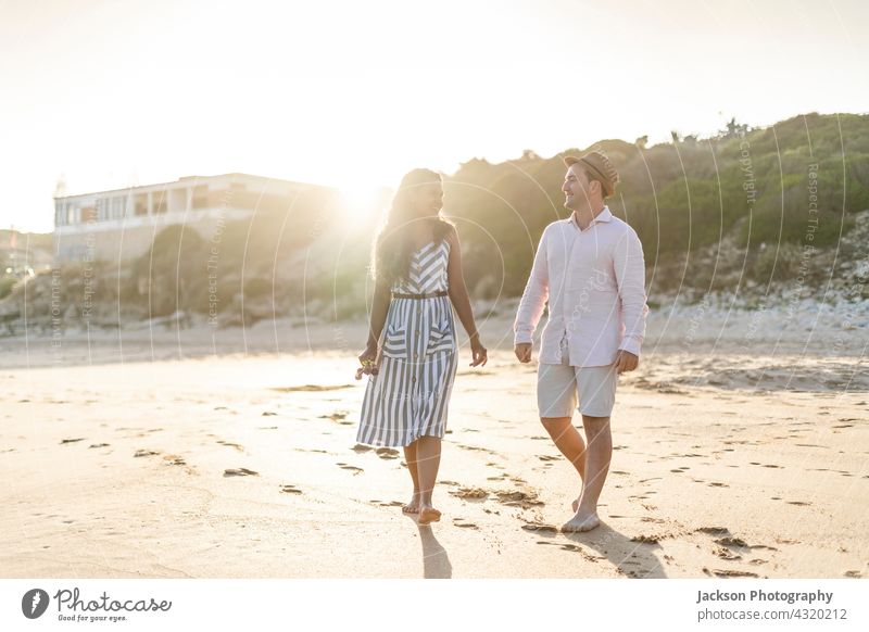 Young couple enjoying time together on the beach people fun love nature lovers summer algarve portugal kiss walk smile active affectionate handsome boyfriend