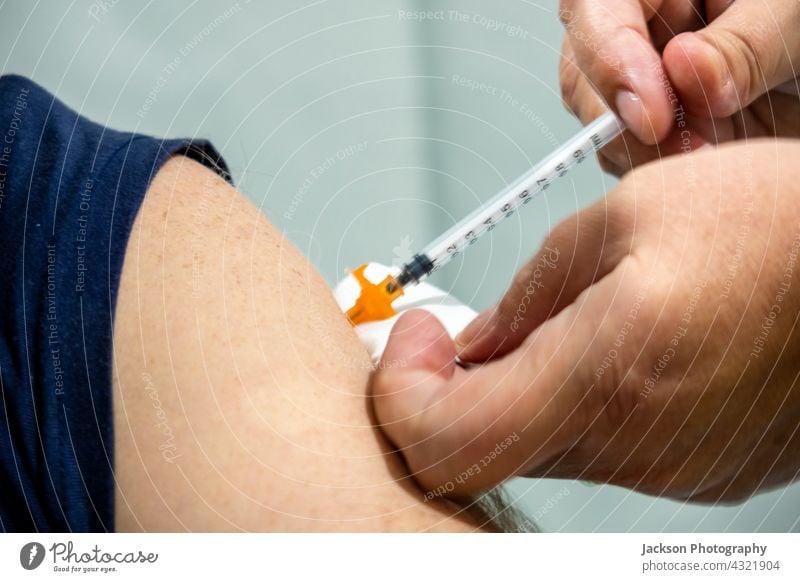 A man getting shot of Covid 19 vaccine syringe vaccination covid 19 needle drug 2019-ncov algarve care clinic corona corona virus coronavirus covid-19