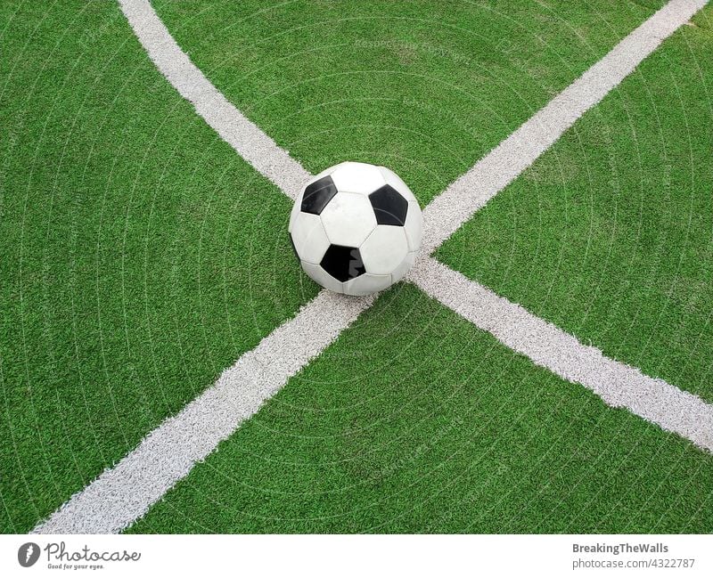 Football ball over green soccer field black white pitch turf artificial closeup marking line sport play game nobody no people copy space outdoors fun active