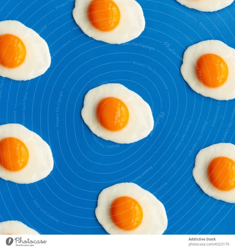 Row of fried eggs on a blue background color design colorful food decoration white holiday celebration natural vintage beautiful traditional retro symbol