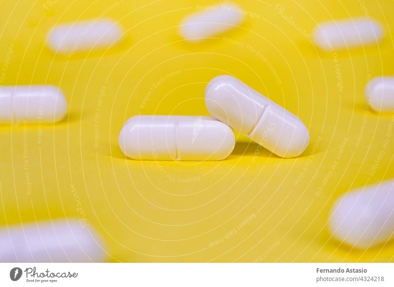 Set of white pills on a yellow background. Horizontal photography. medicine capsule health medical drug pharmacy vitamin tablet isolated medication healthcare