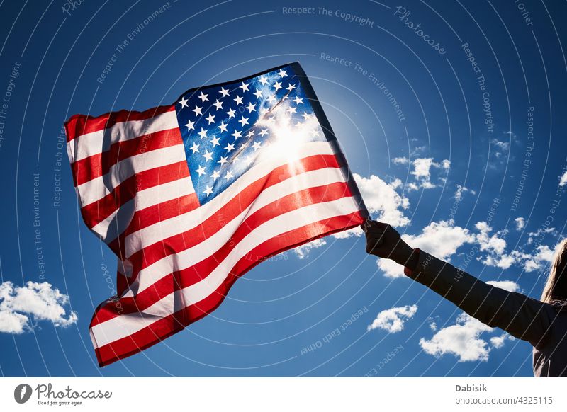 Waving usa flag in hand against blue sky american outdoor 4th july person waving travel people summer day stars stripes background beautiful independence